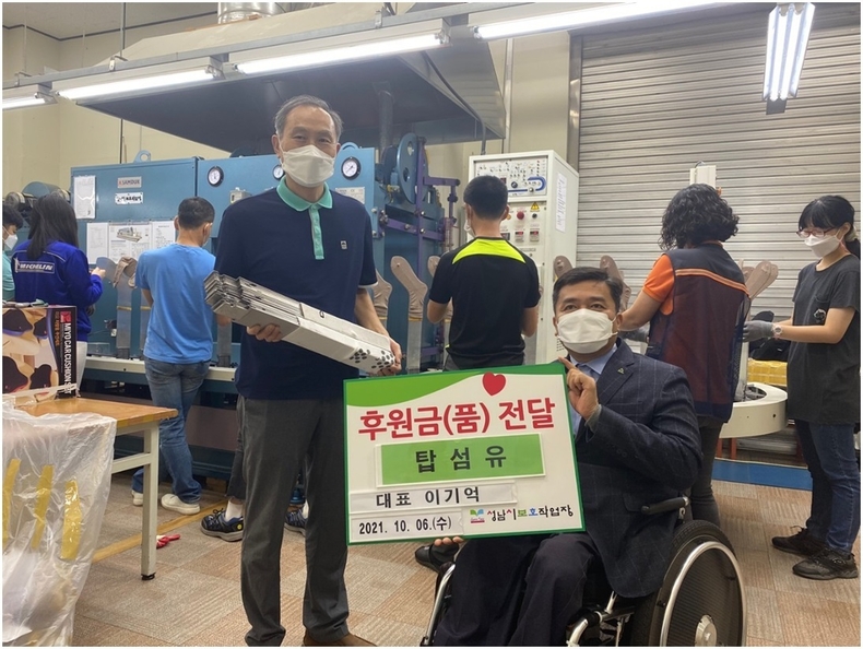 탑섬유 이기억대표가 후원품을 전달하고 있다.