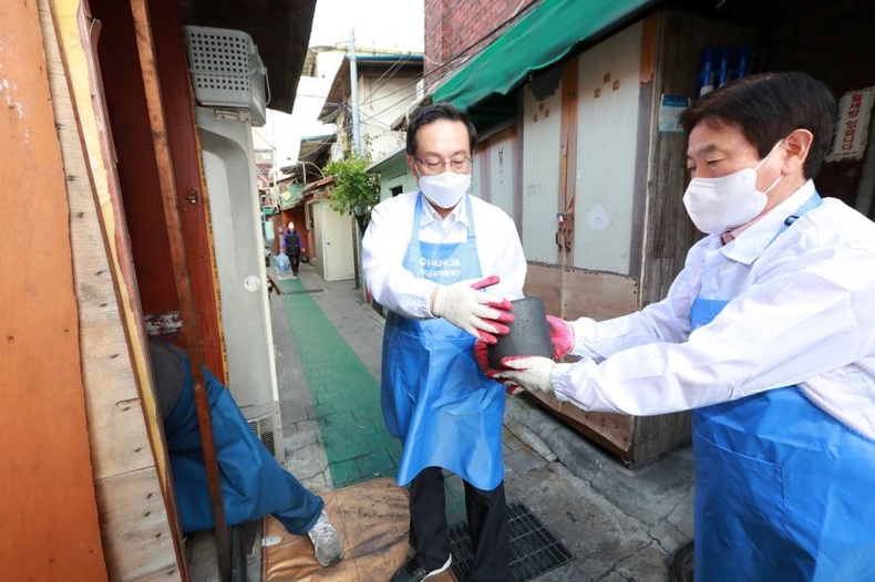 ■ 사진설명2<br>
우리금융그룹 우리금융미래재단 손태승 이사장(왼쪽)과 임직원들이 지난 14일 서울 영등포구 쪽방촌을 방문해 연탄을 옮기고 있다. ⓒ타임즈