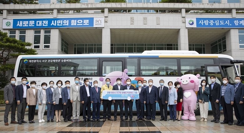 사진 1. 2020년 7월 ‘신협 어부바 차량 지원사업’을 통해 대전 서구청으로 기증된 장애인 특장 버스 앞에서 김윤식 신협사회공헌재단 이사장(가운데) 등 관계자들이 단체 사진을 촬영하고 있다 ⓒ타임즈