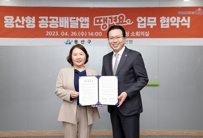  지난 26일 서울시 용산구 소재 용산구청 회의실에서 진행된 ‘용산형 공공배달앱 땡겨요 업무협약식’에서 신한은행 오픈이노베이션 그룹 전필환 부행장(오른쪽)과 용산구청 김선수 부구청장이 협약식 이후 기념 촬영하는 모습 ⓒ타임즈