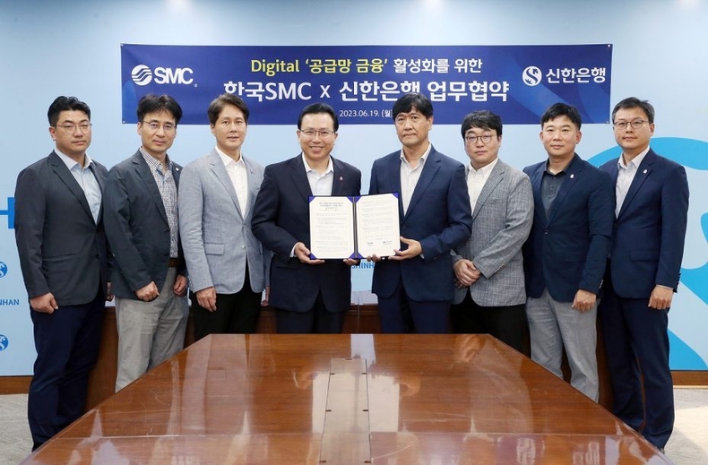 공급망금융02 ⓒ타임즈<br>
사진설명02> 19일 서울시 중구 소재 신한은행 본점에서 신한은행 전필환 디지털혁신부문장(왼쪽 네번째)과 한국SMC 홍성진 관리본부장(왼쪽 다섯번째) 및 양사 직원들이 디지털 ‘공급망 금융’ 활성화를 위한 업무협약식에서 기념촬영하고 있는 모습