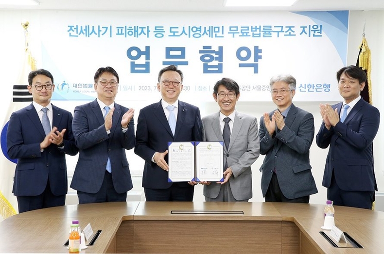 지난 7월 31일 서울시 서초구에 위치한 대한법률구조공단 서울중앙지부에서 진행된 전세사기 피해자 등 도시영세민 무료법률구조 지원 협약식에서 신한은행 정상혁 은행장(왼쪽에서 3번째), 대한법률구조공단 김진수 이사장(왼쪽에서 4번째)이 협약식 이후 관계자들과 기념촬영하는 모습 ⓒ타임즈