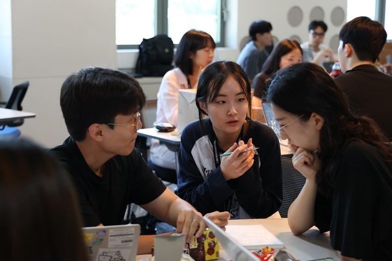 SK텔레콤은 경기도 이천 SK텔레콤 인재개발원에서 개최한 대학생 대상 1박 2일 일정의 AI기술 기반 ‘TECH4GOOD 해커톤’을 성공적으로 마쳤다고 14일 밝혔다.<br>
해커톤 현장에서 대학생들이 멘토와 함께 아이디어 회의를 하고 있다. 2 ⓒ타임즈