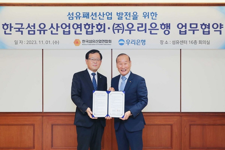 우리은행 섬유산업연합회와 업무협약 체결_1 ⓒ타임즈<br>
■ 사진설명 1 : 우리은행(은행장 조병규)은 지난 1일 강남구 대치동 소재 섬유센터에서 한국섬유산업연합회와 섬유패션산업 발전을 위한 업무협약을 체결했다. 조병규 우리은행장(왼쪽)과 최병오 한국섬유산업연합회 회장이 기념촬영을 하고 있다.