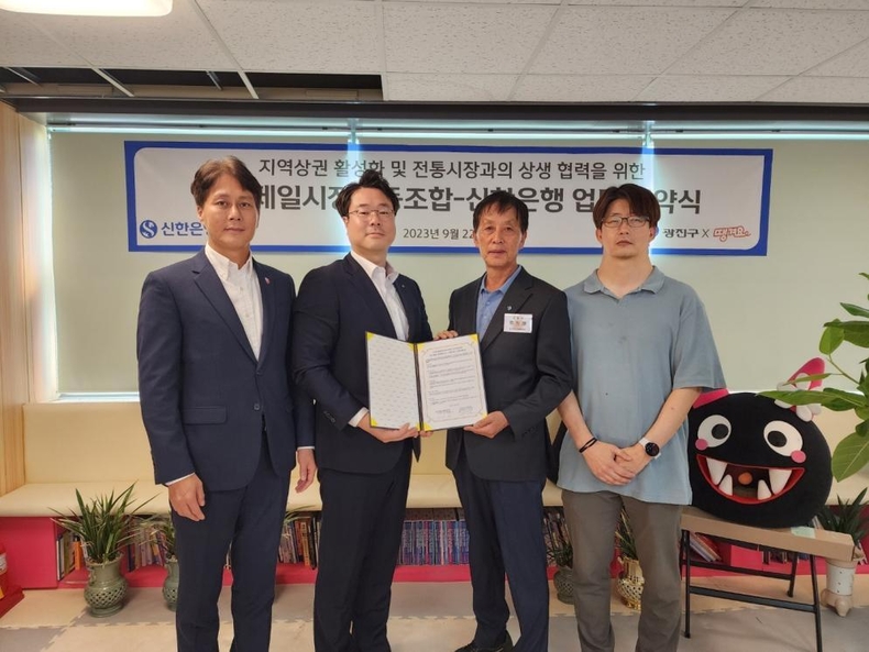 (보도자료이미지2)신한은행, 지역상권과 상생금융을 위한 따뜻한사진설명2) 지난 9월 22일 서울시 광진구에 위치한 중곡제일시장협동조합에서 진행된 ‘중곡제사진설명2) 지난 9월 22일 서울시 광진구에 위치한 중곡제일시장협동조합에서 진행된 ‘중곡제일시장협동조합-신한은행 업무협약식’에서 신한은행 동부본부 김철수 광진커뮤니티장(왼쪽 두번째)과 중곡제일시장협동조합 류정래 이사장(왼쪽 세번째)이 관계자들과 기념촬영하는 모습.