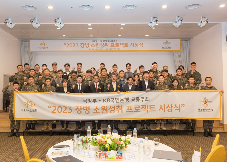 <strong>29일 서울시 용산구에 위치한 국방컨벤션에서 열린 ‘2023 장병소원성취 프로젝트’ 시상식에서 윤봉희 국방부 정책기획관(맨 앞 줄 좌측 6번째), 김동록 KB국민은행 기관고객그룹 대표(맨 앞 줄 좌측 7번째) 및 관계자들이 수상 장병들과 기념사진을 촬영하고 있다. ⓒ타임즈</strong>