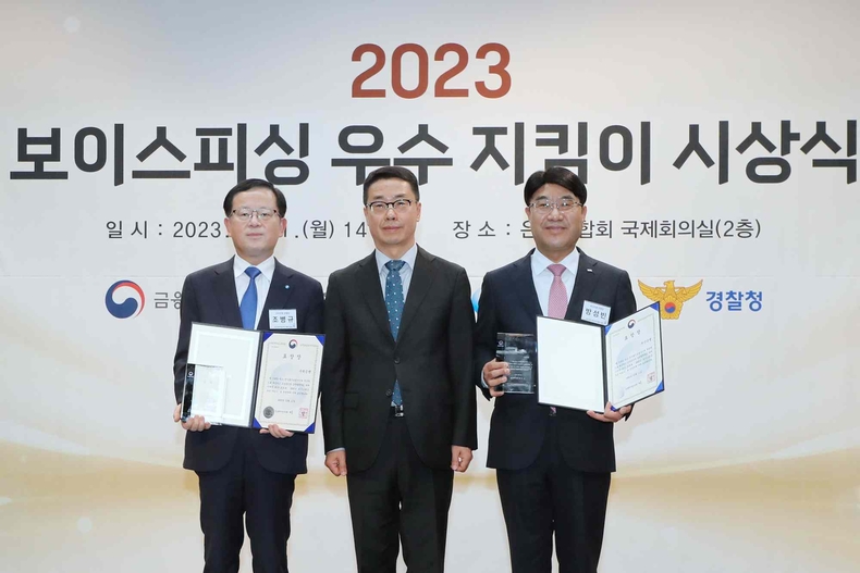 1211 우리은행, 보이스피싱 우수 지킴이 중소벤처기업부 장관 표창 ⓒ타임즈<br>
■ 사진설명 : 우리은행(은행장 조병규)은 지난 11일 은행연합회에서 개최된 제1회 보이스피싱 우수 지킴이 시상식에서 중소벤처기업부 장관 표창을 수상했다. 왼쪽부터 우리은행 조병규 은행장, 중소벤처기업부 원영준 소상공인정책실장이 기념촬영을 하고 있다.