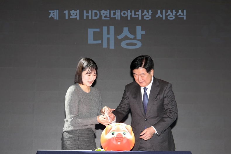 사진1_19일(화) HD현대 글로벌R&D센터에서 열린 제1회 HD현대아너상 시상식에서 ‘얼굴 없는 천사’가 대상을 수상했다. HD현대1%나눔재단 권오갑 이사장(오른쪽)이 '얼굴 없는 천사'를 대신해 전주시 노송동 주민센터 김민아 주무관(왼쪽)에게 대상 상금을 전달하고 있다. ⓒ타임즈