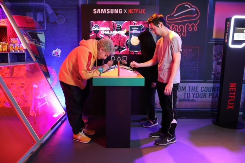 삼성 Neo QLED 8K·갤럭시S23 울트라로 오징어게임 더 트라이얼 생생하게 체험 (2) ⓒ타임즈<br>
2. 삼성전자는 넷플릭스가 미국 로스앤젤레스에 개장한 체험존인 '오징어게임: 더 트라이얼'의 공식 파트너사로 참여했다. 참가자들이 갤럭시 S23 울트라의 S펜으로 디지털 달고나 게임을 즐기고 있다. 