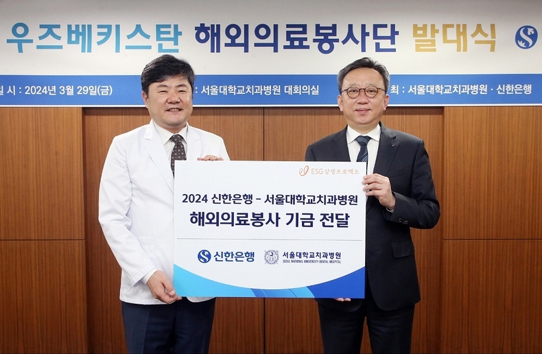 지난 3월 29일 서울시 종로구 소재 서울대학교치과병원에서 진행한 우즈베키스탄 해외의료봉사단 발대식에서 신한은행 정상혁 은행장(오른쪽)이 서울대학교치과병원 이용무 병원장에게 해외의료봉사 기금을 전달하는 모습 ⓒ타임즈 