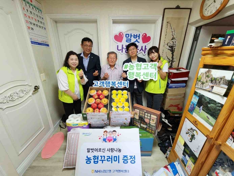 사진설명 : 이강영 농협은행 개인디지털금융부문 부행장(오른쪽에서 두 번째)과 말벗어르신(가운데)을 비롯한 참여자들이 지난 6일 말벗어르신 댁에서 진행한 우리농산물 꾸러미 나눔행사 기념촬영을 하고 있다.