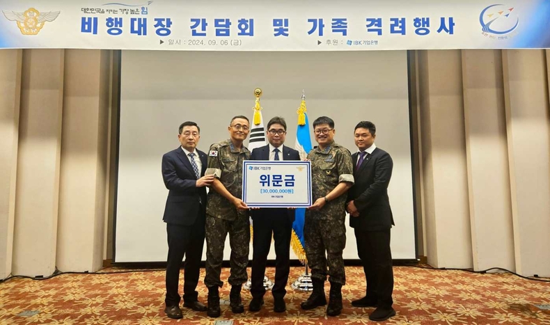 <사진은 지난 6일 부산 해운대 그린나래 호텔에서 열린 공군 가족의 날 기념행사에서 기업은행 관계자가 공군 관계자에게 위문금을 전달하고 기념촬영을 하고 있는 모습> ⓒ타임즈