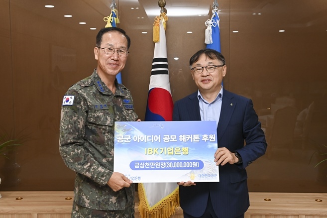 사진은 지난 24일 충남 계룡시 공군본부에서 진행된 후원금 전달식에서 유일광 IBK기업은행 개인고객그룹 부행장(오른쪽)과 손석락 공군참모차장 중장(왼쪽)이 기념촬영을 하고 있는 모습 ⓒ타임즈 