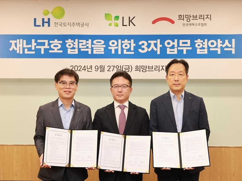 27일 서울시 마포구 희망브리지에서 김경진 LH 주거복지계획처장(왼쪽), 고석민 LK그룹 대표이사(오른쪽), 신승근 희망브리지 부회장(가운데)이 재난구호협력 사업 활성화를 위한 업무협약 기념 촬영을 하고 있다. ⓒ타임즈 