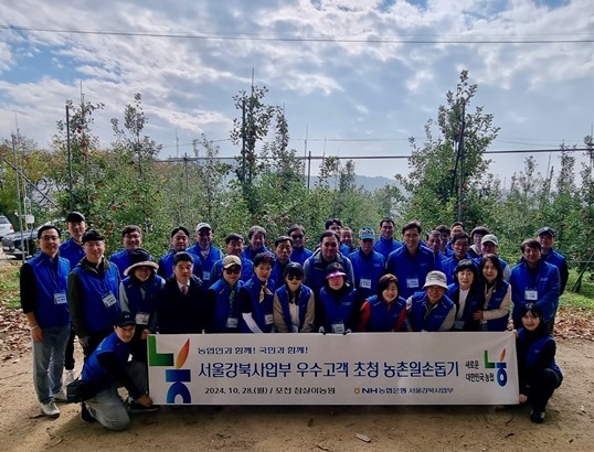 NH농협은행 강승구 서울강북사업본부장(사진 첫째줄 오른쪽에서 세번째)과 지점장 및 우수고객들이 28일 포천시 창수면 소재 사과 농가를 방문해 사과수확 및 일대 자연 정화 활동 등 일손돕기에 구슬땀을 흘렸다. ⓒ타임즈 