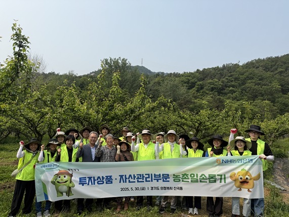  지난 30일 의정부시 송산로 배 과수농가에서 농촌일손돕기 봉사활동을 마친 후 NH농협은행 이영우 투자상품·자산관리부문장(가운데) 등 임직원들이 기념촬영을 하고 있다. ⓒ타임즈 