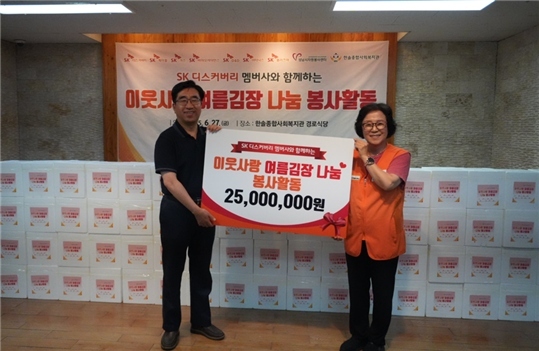 이용석 SK디커버리 SV위원장이 장현자 센터장에게 2천500만원 상당 김치를 전달하고 있다. ⓒ타임즈 