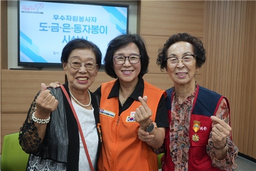 도자봉이(2만시간 이상) 훈장을 수상한 김의경(좌), 안옥자(우) 자원봉사자와 장현자 센터장(중앙). ⓒ타임즈 