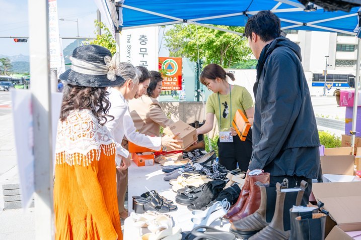 광화문원팀 바자회에 참가한 임직원들이 물건을 건네고 있다. ⓒ타임즈 