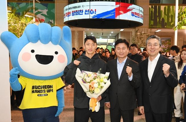 지난해 11월, 부천시청을 방문한 황희찬 선수와 조용익 부천시장, 권세광 부천희망재단 이사장과 시청 1층 로비에서 기념사진 촬영을 하고 있다.