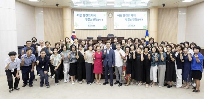 박태순 의장(사진 가운데)과 현옥순 의회운영부위원장(사진 가운데서 왼쪽)이 이동 통장협의회 회원들과 의회 본회의장에서 기념 촬영에 임하고 있는 모습.