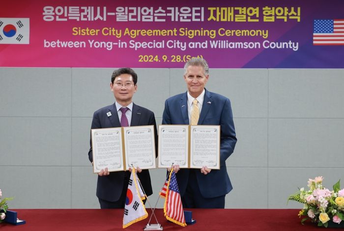 이상일 용인특례시장이 28일 용인시민의 날 행사 현장에서 빌 그래벨 미국 텍사스주 윌리엄슨 카운티장과 자매결연 협약을 맺고 협약서에 서명했다