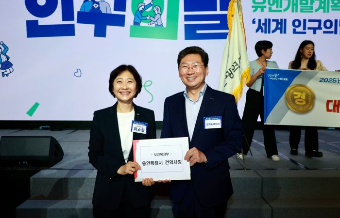 이상일 용인특례시장(오른쪽)이 11일 '제14회 인구의 날' 기념식에서 이스란 보건복지부 제1차관(왼쪽)에게 사회복지 서비스 제도개선 내용을 담은 건의문을 전달했다.