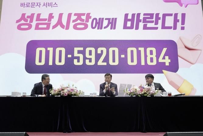 신상진 성남시장이 시민과의 새해인사회에서 업무용 휴대폰을 들고 바로 문자 서비스에 대해 설명하고 있다
