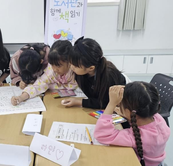 도서관과 함께 책 읽기 프로그램에 참여하고 있는 어린이들