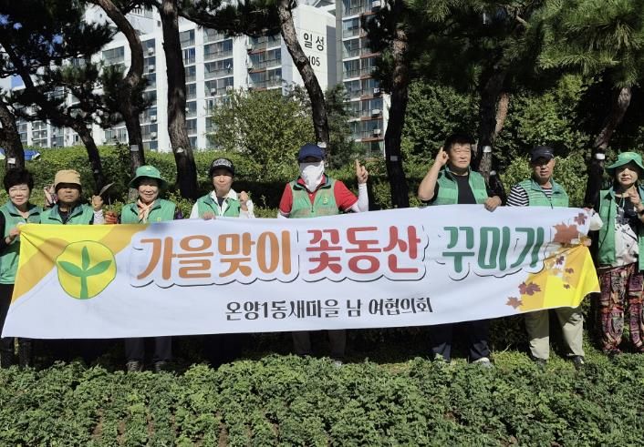 양1동 새마을지도자협의회 회원들이 가을꽃 식재를 마친 후 기념촬영을 하고 있는 모습